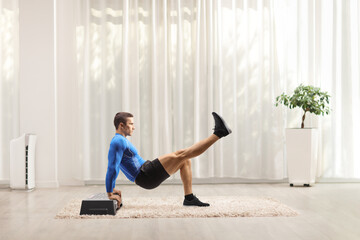 Wall Mural - Fit strong man exercising on a step aerobic platform with his leg up