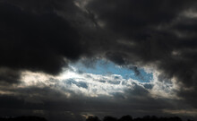 A Blue Eye Sky Peaks Through Stormy Black Clouds 