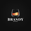 © Pushkarevskyy - Brandy glass logo. Golden whiskey or cognac