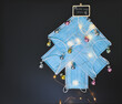 View of a Christmas tree made of blue surgical masks decorated with colorful Christmas baubles and Christmas lights against black chalkboar background. Christmas during pandemic or medical background.
