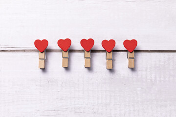 Poster - Beautiful shot of red hearts on clothespins on a white background