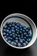 Sticker - Side shot of a bowl of blueberries. Clean just-washed fruit in your plate on the table