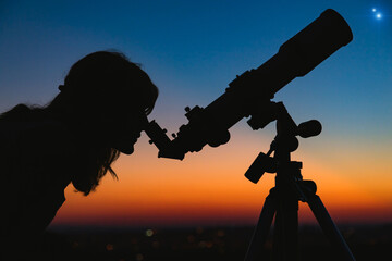 Wall Mural - woman looking at night sky with amateur astronomical telescope.