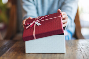 Wall Mural - Closeup image of a woman opening a gift box