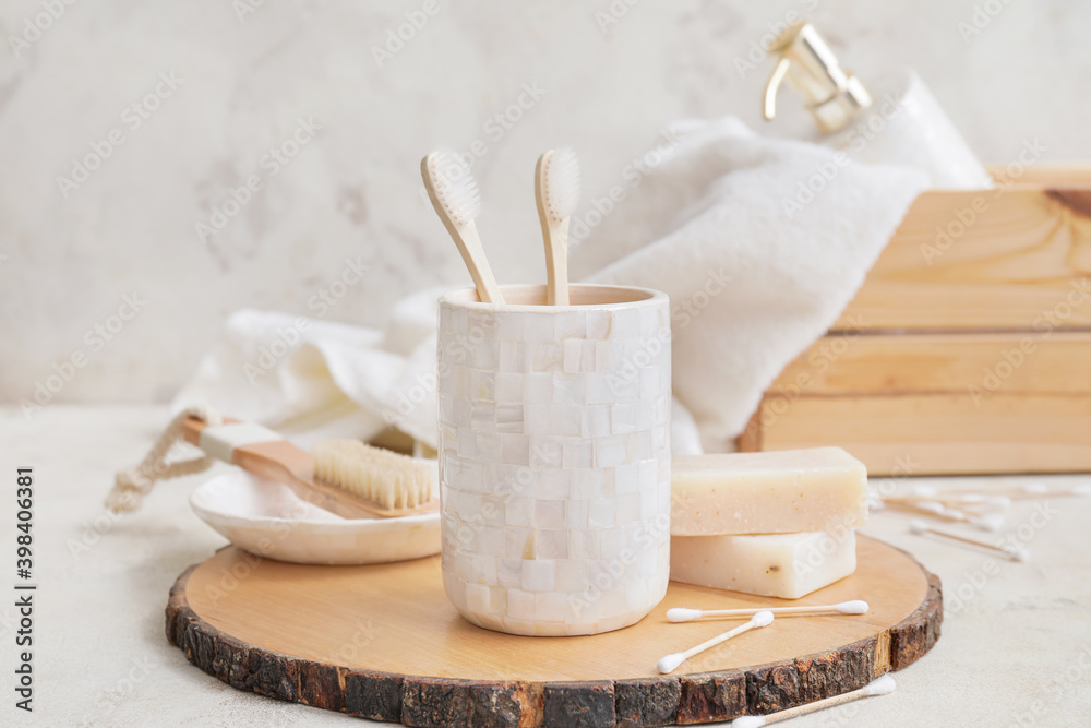 Wooden board with set of bath accessories on table