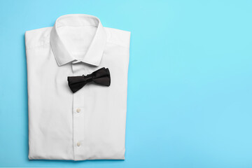 New male shirt and bow tie on color background