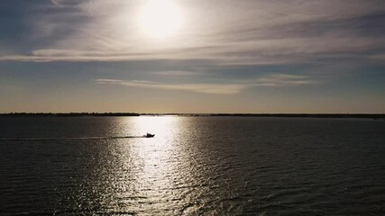 Wall Mural - beautiful aerial over lake erie as a boat speeds across the water through the reflected sunlight tha