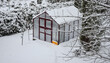 Gewächshaus mit viel Schnee im Winter im Garten