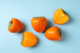 Fresh ripe persimmon on blue background, top view