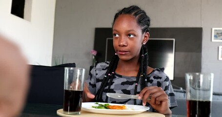 Wall Mural - Black African girl eating lunch salad at table with family