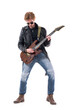 © sharplaninac - Macho young stylish man rock musician playing electric guitar solo looking down. Full body length isolated on white background.