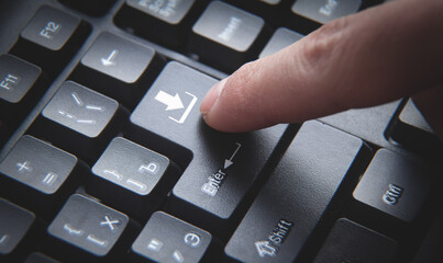 Human hand pressing download button on keyboard.