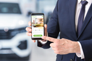 Poster - Businessman with mobile phone booking room in hotel online, closeup