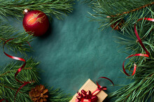 Christmas Background, Composition With Pine Tree Branches And Red Decorations On Green Paper Background