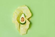 Organic Fabric Covers For Food Storage. Reusable Beeswax Food Wraps With Half Of Avocado On Green Background.