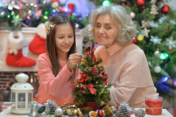 Sticker - Smiling little girl with grandmother preparing for Christmas