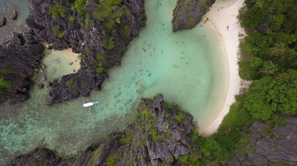 Wall Mural - Aerial top down view of tourists at tropical paradise Hidden Beach in El Nido, Palawan, Philippines. El Nido is famous for its island hopping and snorkeling tours to secluded beaches.