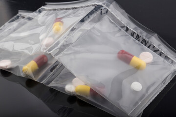 pills in a plastic bag on a black background.