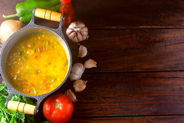 Pirão is a traditional dish of Brazilian cuisine made from cassava flour, fish or shrimp, in a pan on a rustic wooden table.