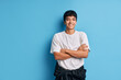 © GVS - Happy mixed race man with crossed arms posing on blue background