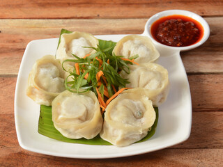 Wall Mural - Chicken cheese momo. Nepalese Traditional dish Momo stuffed with chicken and cheese and then cooked and served over a rustic wooden background, selective focus