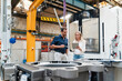 © Daniel Ingold/Westend61 - Businesswoman using digital tablet while male colleague standing beside in factory