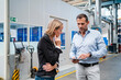 © Daniel Ingold/Westend61 - Businessman explaining female colleague over digital tablet while standing at factory