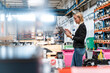 © Daniel Ingold/Westend61 - Female entrepreneur using digital tablet while standing in industry