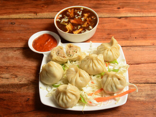 Wall Mural - Chicken steam momo and chicken soup, Nepalese Traditional dish Momo stuffed with chicken and then cooked and served over a rustic wooden background, selective focus