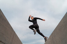 Sportsman Jumping On Wall Against Sky