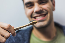 Smiling Man Brushing Teeth With Bamboo Toothbrush
