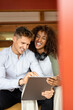 © peter scholl/Westend61 - Smiling couple using digital tablet while sitting at home