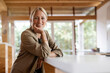 © peter scholl/Westend61 - Mature businesswoman sitting with hand on chin at home