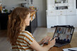 © Rainer Berg/Westend61 - Woman talking on video conference through laptop while sitting at home