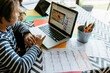 © VALENTINA BARRETO STUDIO/Westend61 - Boy watching online video on laptop while sitting at table