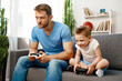 © fotofabrika - Father and his little son playing video games together at home