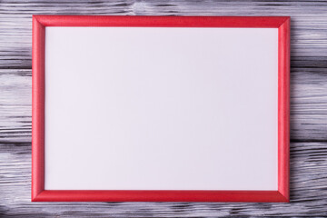 Wall Mural - Blank white card in red frame on old wooden background