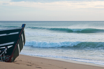 Abandoned wooden dinghy boat at the sandy coasts of Cadiz in Andalusia, Spain