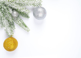 Christmas decorative silver and gold balls on a spruce branch in the snow, on a white background.With copy space