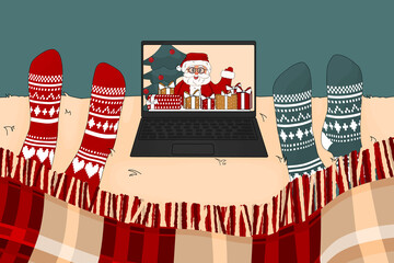 Two people are watching movie or tv program about Santa Claus in Christmas time under the plaid in knitted socks