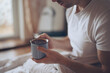 © antgor - Man drinks hot tea at the morning sitting in a bed
