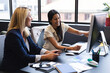 © Wavebreak Media - Diverse businesswomen sitting by desk using computer discussing in office