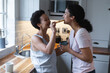 © Wavebreak Media - Happy mixed race lesbian couple having toast and coffee for breakfast in kitchen