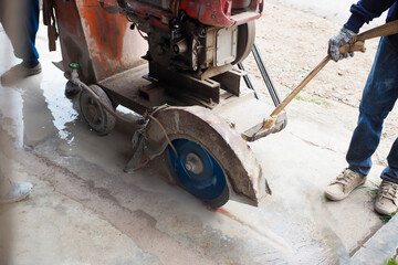 Road workers cutting concrete road