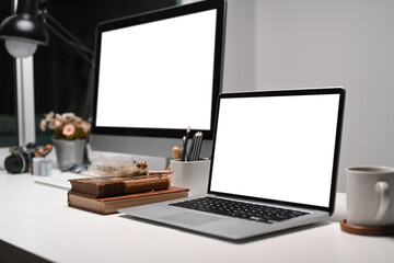 Multiple display devices on modern office desk with blank screen for responsive web desing promotion.