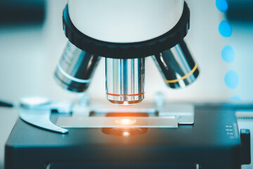 Close up of microscope with test sample in medical research lab or science laboratory.