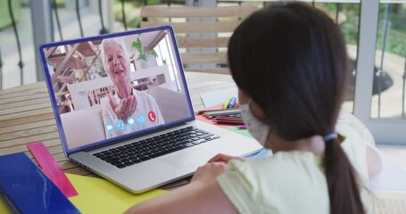 Canvas Print - Caucasian girl on laptop video chat wearing face mask at home