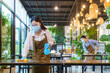 © Prasit Rodphan - Portrait attractive Asian restaurant employee wear face mask and face shield cleaning table and floor with alcohol and wet wipe before welcome customer.