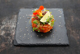 Fototapeta  - Salmon tartare with edible florals. A light appetizing appetizer