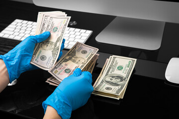 Wall Mural - dollars in hand in blue medical gloves. Coronavirus crisis. Save money.